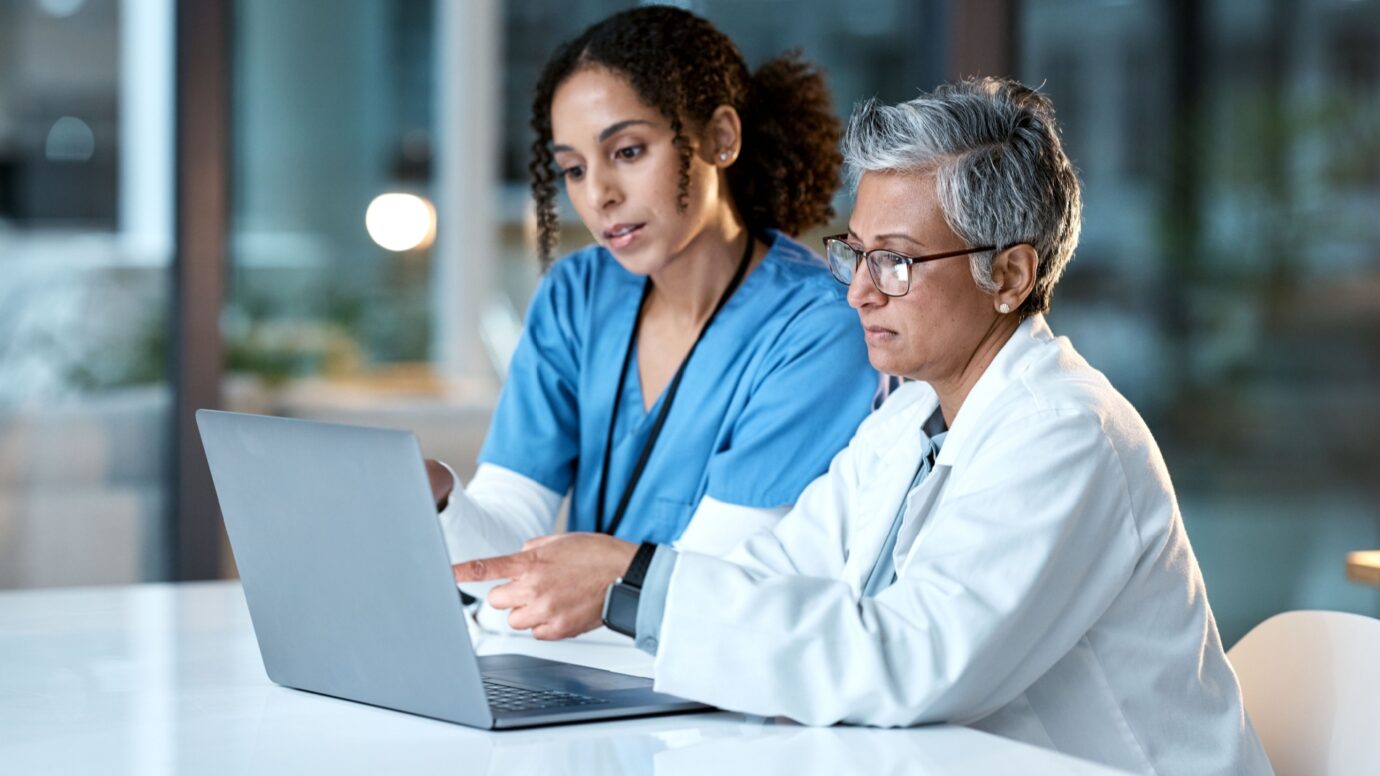 Doctor looking at information on a laptop with a nurse