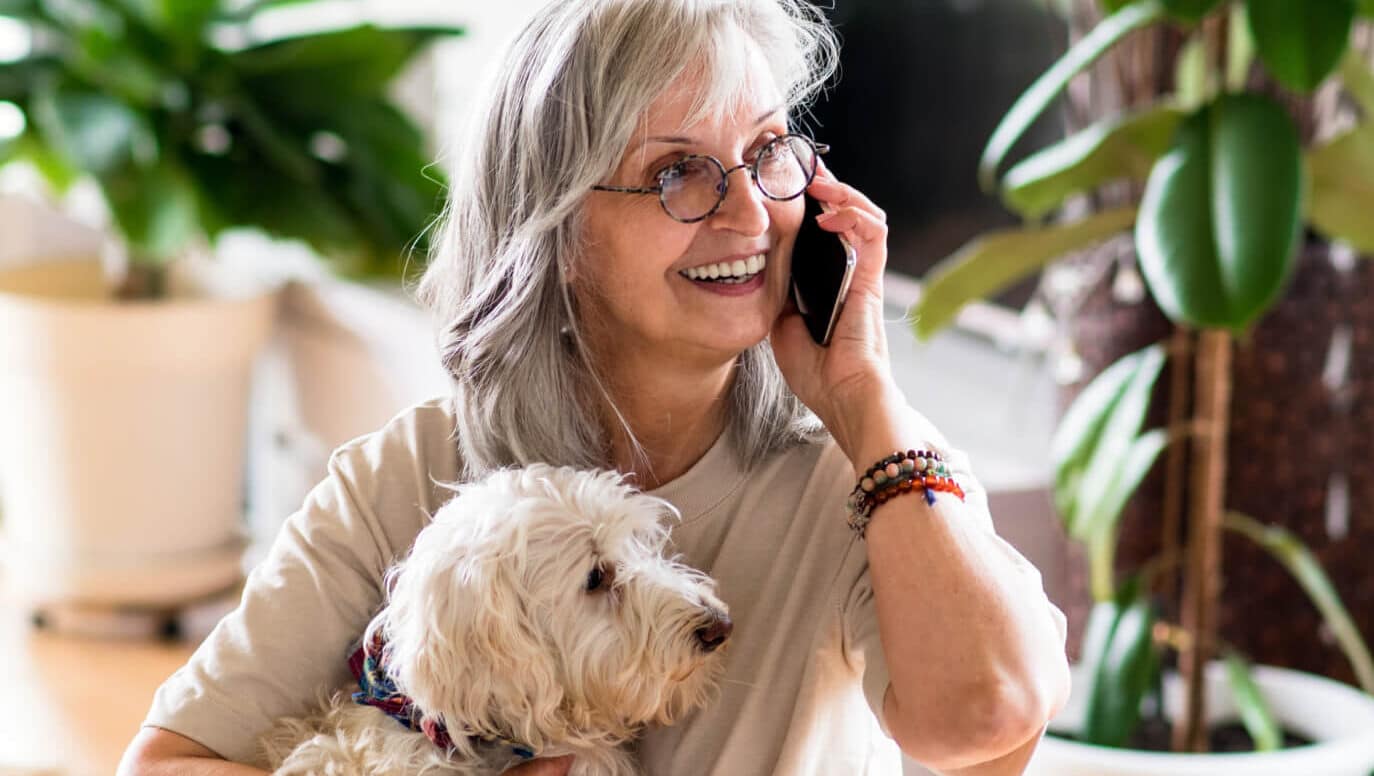 Woman on the phone while holding her dog