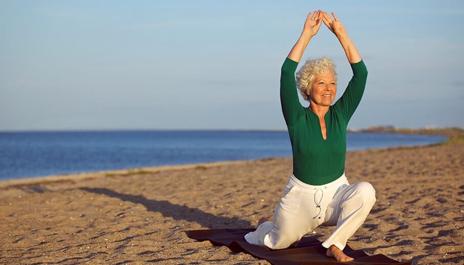 woman doing yoga on the beach